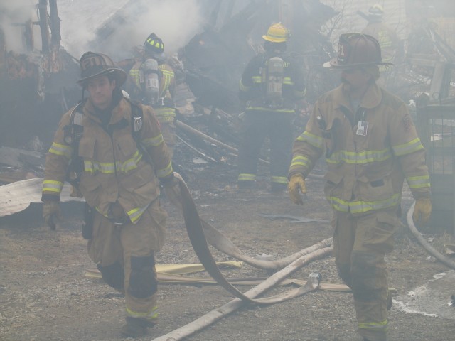 Lieutenant Win Slauch and Firefighter Mike Nelson dragging the blitz line at a West Grove fire.